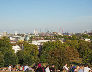 Group of people in city against sky