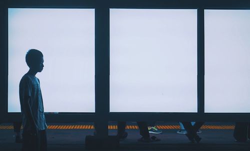 Low angle view of silhouette woman standing against window