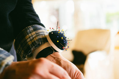 Cropped hand of fashion designer with pin cushion