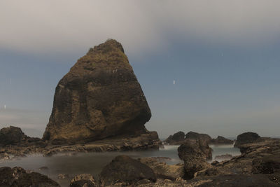 Rocks on sea shore against sky