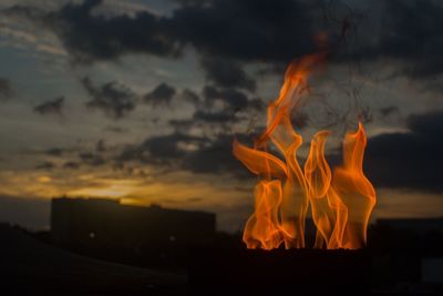 Close-up of fire against sky during sunset