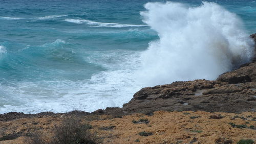 View of waves breaking on rocks