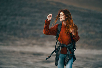 Woman holding umbrella while standing on land