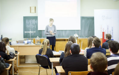 Rear view of students sitting in classroom