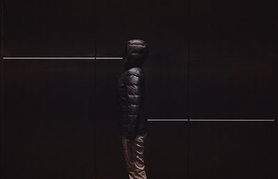 Digital composite image of young man standing against wall