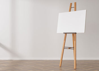 Empty horizontal canvas on wooden easel standing in room. free, copy space for your picture