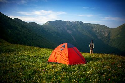 Tent on grassy field against mountains