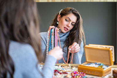 Portrait of beautiful young woman sitting on table