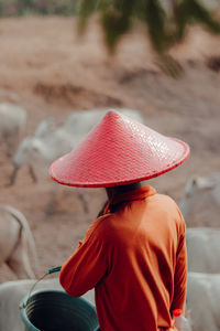 Rear view of farmer wearing red hat