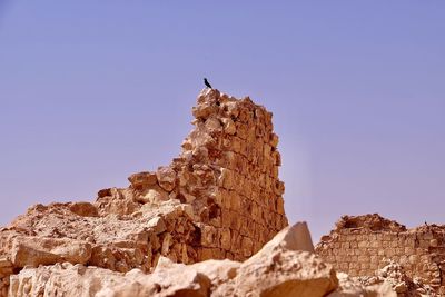 Low angle view of rock formation against clear sky in massada, israel 