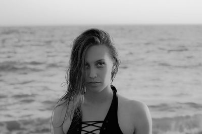 Close-up portrait of young woman standing at beach