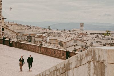 Rear view of people walking on buildings in city