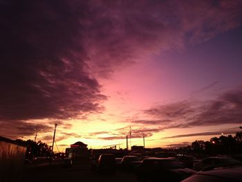 Silhouette trees against dramatic sky during sunset