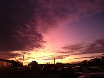 Silhouette trees against dramatic sky during sunset