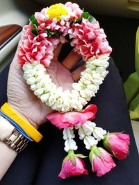 Close-up of hand holding bouquet of pink roses