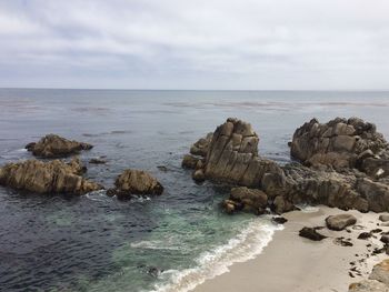 Rocks on sea shore against sky