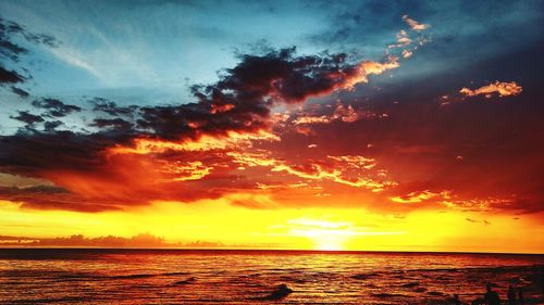 Scenic view of sea against dramatic sky during sunset