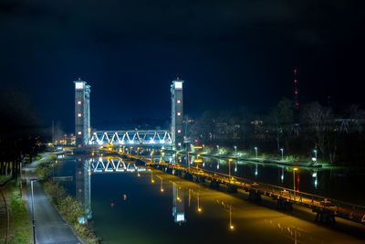 Railway bridge reflecting on the water surface in the canal in the evening