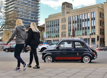 Side view of people walking on city street