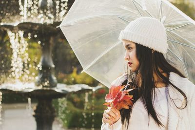 Close-up of woman holding wet umbrella