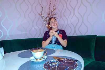 Portrait of young woman sitting on table