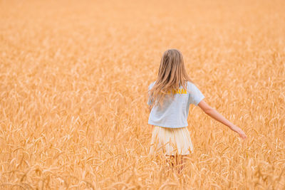 Rear view of girl standing on farm