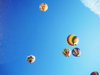 Low angle view of hot air balloons against blue sky