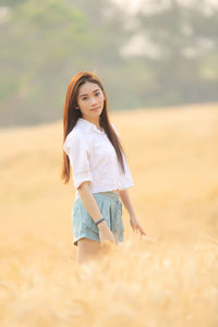 Portrait of woman standing on field