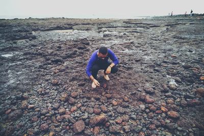 Full length of man crouching at beach