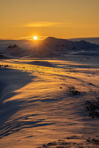 Scenic view of snowcapped mountains against sky during sunset