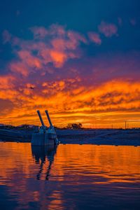 Silhouette boat moored on sea against sky during sunset