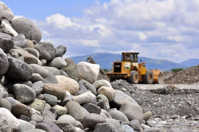 Pebbles at construction site against sky