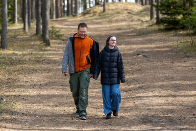 Rear view of couple walking on field