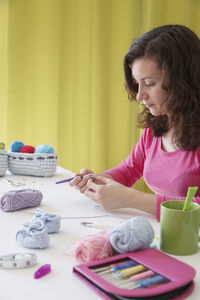 Woman looking away while sitting on table