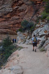 Rear view of people walking on rocks