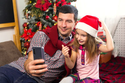 Young woman sitting in a christmas tree