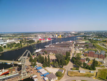High angle view of buildings by sea against clear sky