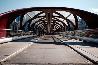 Footbridge over river in city against clear sky