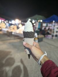 Midsection of person holding ice cream in city