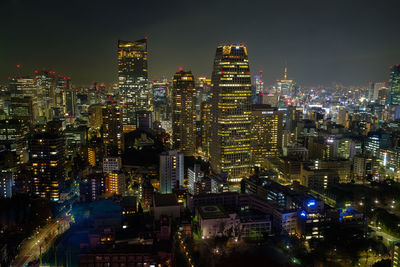 Illuminated cityscape against sky at night