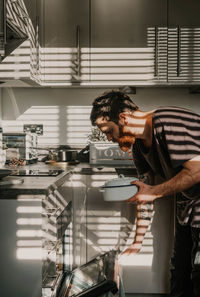 Side view of man preparing food at home