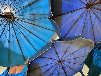 Low angle view of umbrella against blue sky