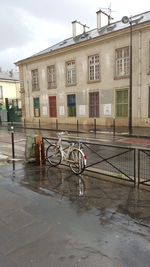 Bicycle by building against sky