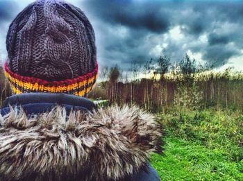 People on grass against cloudy sky
