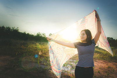 Portrait of smiling young woman standing on field