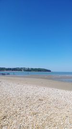 Scenic view of beach against clear blue sky