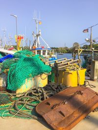 Fishing net at harbor against clear blue sky
