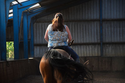 Rear view of woman in stable