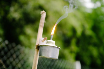 Close-up of burning candle against blurred background