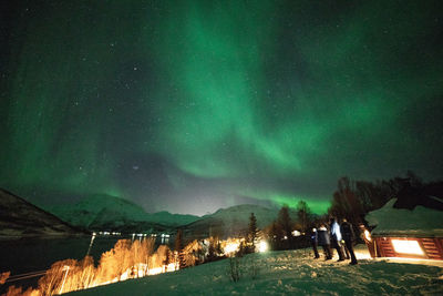 Scenic view of illuminated snowcapped mountains against sky at night